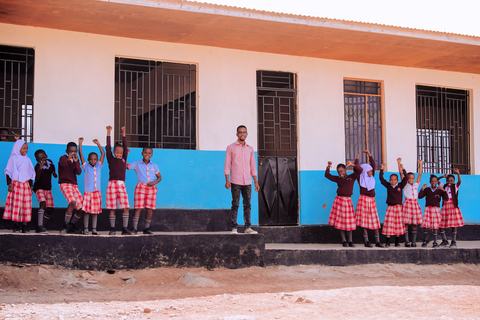 Pupils lined up with a teacher along the classroom block