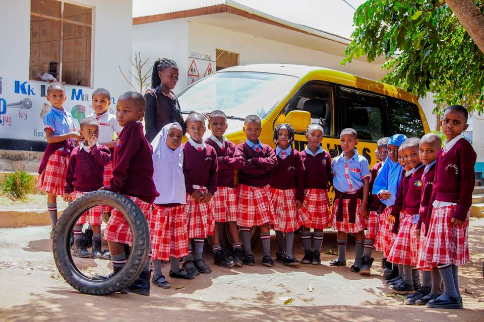 Jupe Hills pupils standing beside the school van
